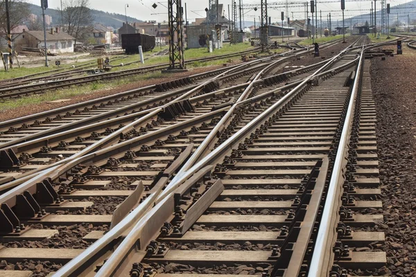 La strada in avanti ferrovia, attraversando i binari vicino alla stazione rurale — Foto Stock