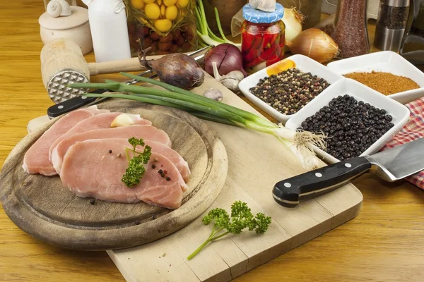 Accueil Préparation des aliments dans la cuisine, rôti de porc sur gril, porc cru sur planche à découper et légumes — Photo