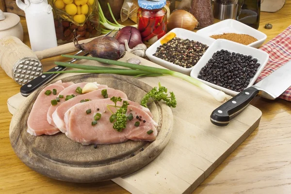 Accueil Préparation des aliments dans la cuisine, rôti de porc sur gril, porc cru sur planche à découper et légumes — Photo