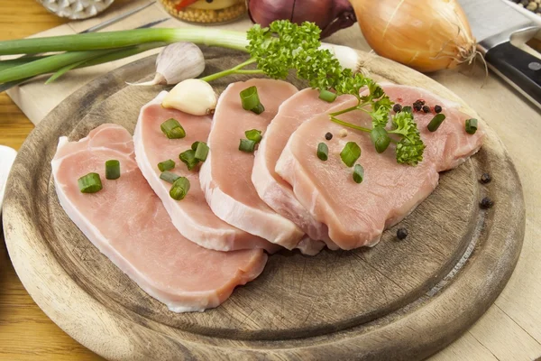 Home food preparation in the kitchen, roast pork on grill, Raw pork on cutting board and vegetables — Stock Photo, Image