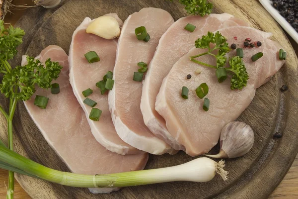 Home food preparation in the kitchen, roast pork on grill, Raw pork on cutting board and vegetables — Stock Photo, Image