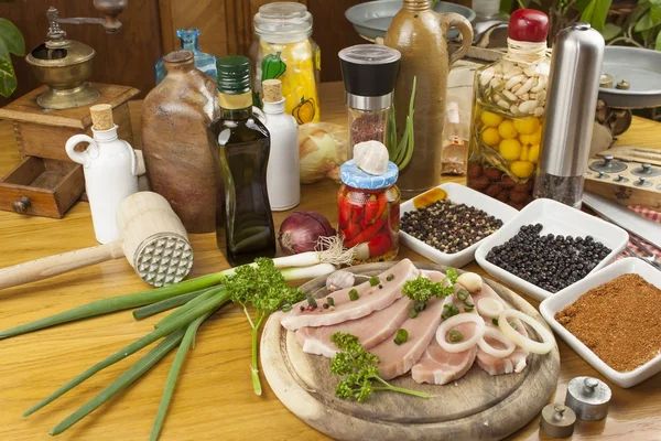 Home preparação de alimentos na cozinha, carne de porco assada na grelha, carne de porco crua na tábua de corte e legumes — Fotografia de Stock