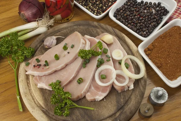 Accueil Préparation des aliments dans la cuisine, rôti de porc sur gril, porc cru sur planche à découper et légumes — Photo