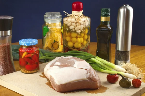 Fresh raw pork on a cutting board with vegetables — Stock Photo, Image