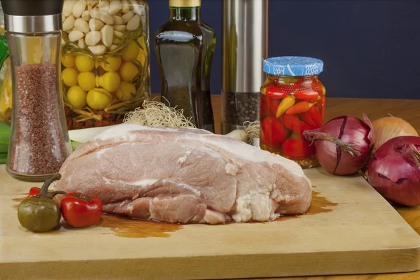 Fresh raw pork on a cutting board with vegetables