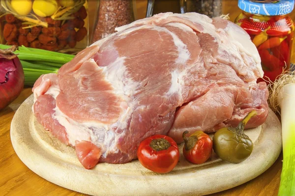 Porc cru frais sur une planche à découper avec des légumes — Photo