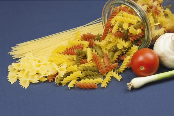 Diferentes tipos de massas na mesa, juntamente com legumes, prontos para cozinhar — Fotografia de Stock