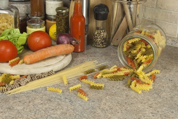 Pratos de massa para casa. Massas, especiarias e legumes na mesa da cozinha — Fotografia de Stock