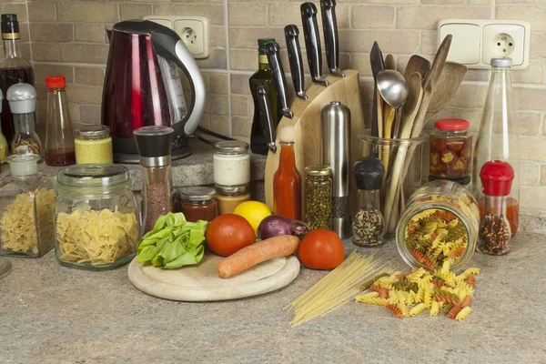 Homework pasta dishes. Pasta, spices and vegetables on the kitchen table — Stock Photo, Image