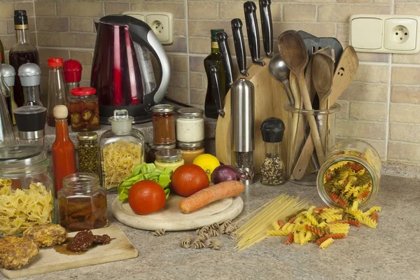 Homework pasta dishes. Pasta, spices and vegetables on the kitchen table — Stock Photo, Image