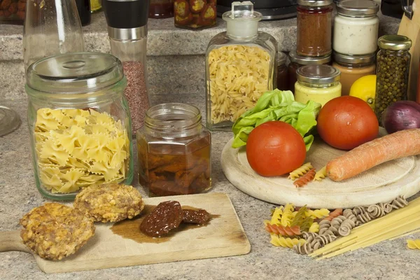 Platos de pasta para tareas. Pasta, especias y verduras en la mesa de la cocina — Foto de Stock