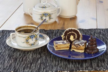 tatlı kahve, çikolatalı kek ve tablo üzerinde rulo ile arka plan bulanık