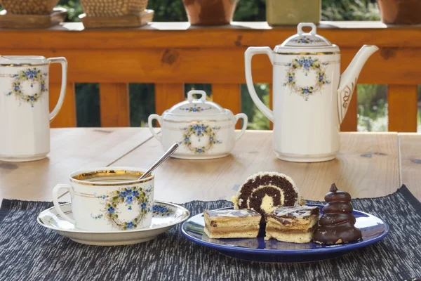 Sobremesa com café, bolos de chocolate e rolos na mesa, fundo embaçado — Fotografia de Stock