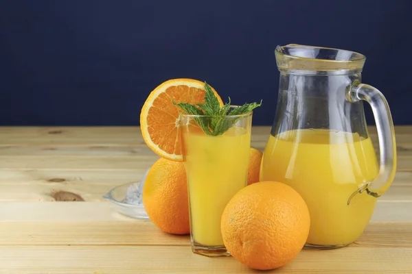 国内鲜橙汁在木制的桌子上的玻璃罐子里. — 图库照片