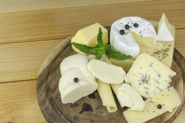 Varios tipos de queso en una tabla de cortar, hecho de leche de vaca . —  Fotos de Stock