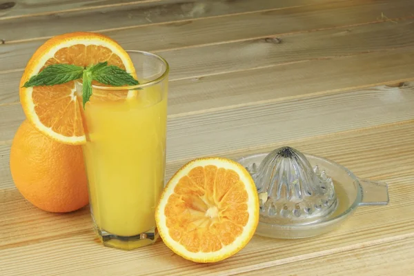 Domestic fresh orange juice in a glass  on a wooden table. — Stock Photo, Image