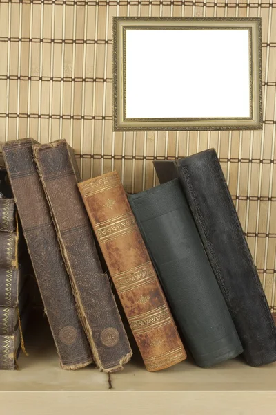 Front view of old books stacked on a shelf. Books without title and author. old picture frame for your text. — Stock Photo, Image