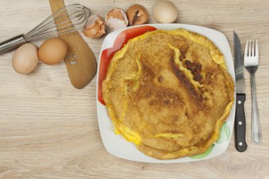 ahşap bir masa üzerine çırpılmış yumurta omlet. bir tabak yemek.