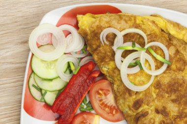 ahşap bir masa üzerinde sebze ile çırpılmış yumurta omlet. lokanta ev hazırlanması.
