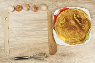ahşap bir masa üzerine çırpılmış yumurta omlet. bir tabak yemek.