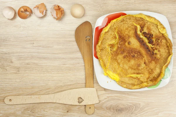 炒的蛋煎蛋卷在一张木桌上。一盘食物. — 图库照片