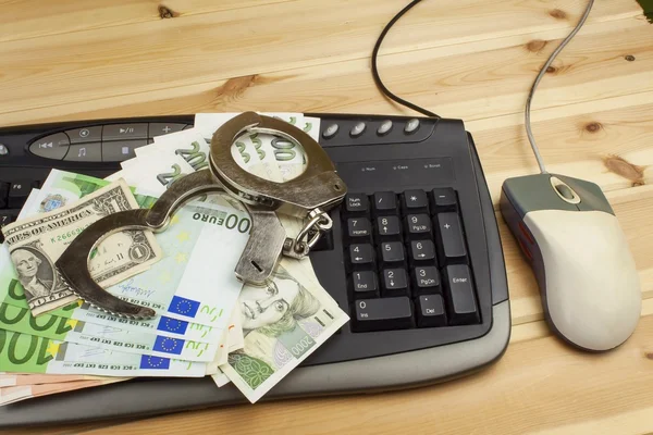 The concept of cybercrime. Criminal activity performed by computers and the Internet. Valid banknotes euro and the Czech koruna. Arrest cybercriminals, metal handcuffs and computer keyboard. — Stock fotografie