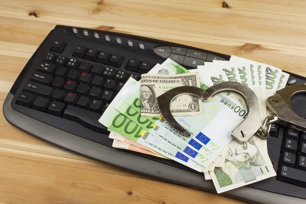 The concept of cybercrime. Criminal activity performed by computers and the Internet. Valid banknotes euro and the Czech koruna. Arrest cybercriminals, metal handcuffs and computer keyboard. — Stock Photo, Image