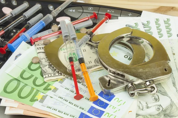 The concept of cybercrime. Illegal sales of medications and drugs over the Internet. Valid banknotes euro and the Czech koruna. Arrest cybercriminals, metal handcuffs and computer keyboard. — Stock Photo, Image