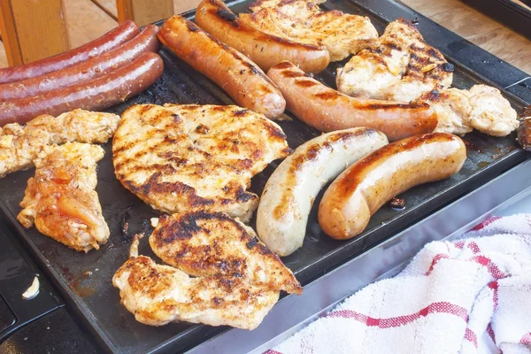 Barbecue on the electric grill.  Summer party, detailed view of grilled chicken and sausage. — Stok fotoğraf