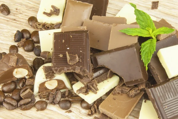 Des morceaux de chocolat sur une planche de bois. Le plaisir du chocolat sucré sur la table . — Photo