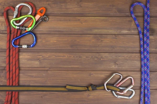 Used climbing gear on wooden background. Advertising boards of trade. The concept of extreme sports. Decoration of older equipment climbers.