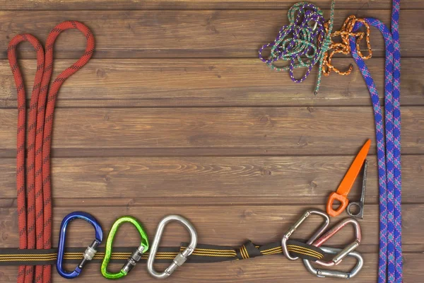 Used climbing gear on wooden background. Advertising boards of trade. The concept of extreme sports. Decoration of older equipment climbers.