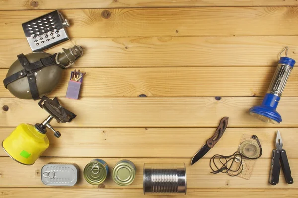 Preparándose para acampar en verano. Cosas necesarias para una aventura épica. Venta de equipos de camping. Equipo de embalaje para acampar. Equipo de camping en una tabla de madera . —  Fotos de Stock