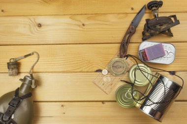 Preparing for summer camping. Things needed for an epic adventure. Sales of camping equipment. Packaging equipment for camping. Camping equipment on a wooden board.