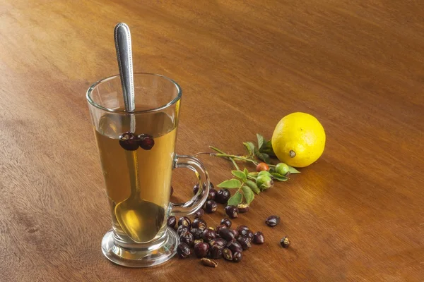 Горячий чай с лимоном и красной стрелкой в столе. Домашнее лечение простуды и гриппа. Лечение простуды по традиционным рецептам . — стоковое фото