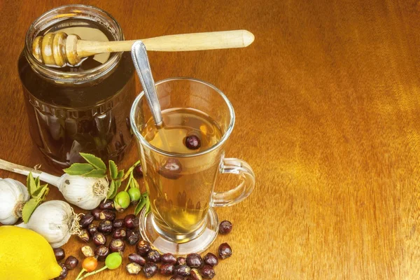 Traditional home treatment for colds and flu. Rosehip tea, garlic, honey and citrus. Hot tea with honey and lemon on a wooden tabletop. Home Pharmacy. — Φωτογραφία Αρχείου