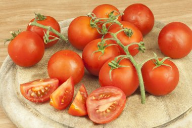 Fresh tomatoes on the kitchen table. Tomatoes on a wooden cutting board. Domestic cultivation of vegetables. Fresh organic food ready to cook. Fresh dietary ingredients. Raw vegetables to raw food.