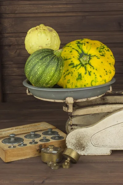 Autumn harvest of pumpkins. Preparing for Halloween. Growing vegetables in a home garden. Place for your text. Autumn pumpkins with leaves on wooden board. Old kitchen scale vegetable.