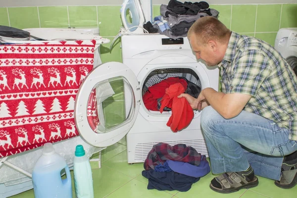 Man washes clothes in the washing machine. Housework men. Man helping his wife when washing clothes. The division of housework. Man Near The Washing Machine. — Stock Photo, Image