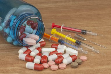 Doping in sport. Abuse of anabolic steroids for sports. Anabolic steroids spilled on a wooden table. Fraud in sports. Pharmaceutical industry. Detailed view of the medication. Place for your text. clipart