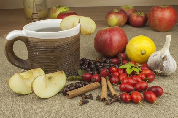 Une épidémie de grippe. Traitement à domicile traditionnel contre le rhume et la grippe. Thé rose musquée, miel et agrumes. Thé chaud au miel et au citron sur une table. Pharmacie à domicile. Traitement éprouvé des maladies . — Photo