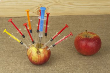 Genetik modifikasyon kavramı. Meyve ve syginge. Apple hızlı olgunlaşma için bazı madde enjeksiyonu alma. Kimya tarım sektöründe. Elma ve şırınga.