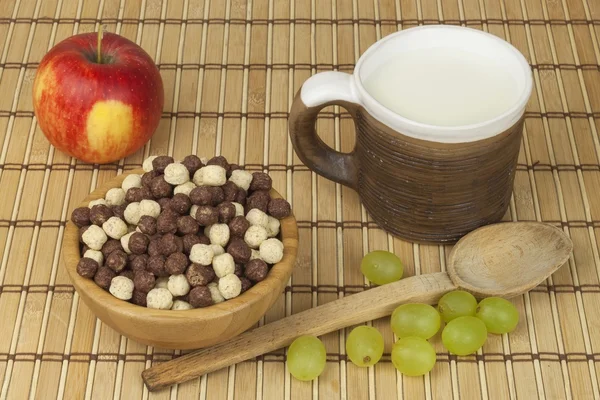 Chocolate cereal balls in a bowl of bamboo. Healthy breakfast with fruit and milk. A diet full of energy and fiber for athletes. Quick to prepare homemade breakfast. — ストック写真