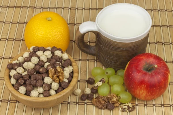 Chocolate cereal balls in a bowl of bamboo. Healthy breakfast with fruit and milk. A diet full of energy and fiber for athletes. Quick to prepare homemade breakfast. — Stockfoto