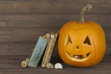 Ahşap arka plan üzerinde Halloween Kabak kafa. Cadılar Bayramı için hazırlanıyor. Kafa Cadılar Bayramı'nda bir kabak oyma. Kabak geleneği. Büyü, büyülü kitap kitap. Cadılar için ders kitapları.
