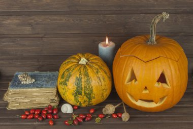 Ahşap arka plan üzerinde Halloween Kabak kafa. Cadılar Bayramı için hazırlanıyor. Kafa Cadılar Bayramı'nda bir kabak oyma. Kabak geleneği. Büyü, büyülü kitap kitap. Cadılar için ders kitapları.