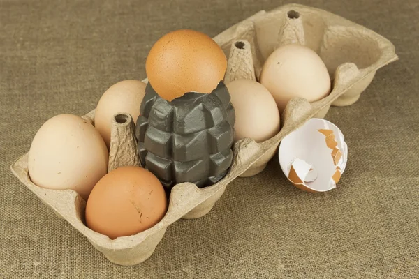 Handgranat - ett ägg. Granat mellan ägg. Explosiv ägg, rolig bild. Hemlagad kyckling ägg. Traditionell mat med protein. Ägg på bordet, beredning av livsmedel. Förbereda ägg omelett. — Stockfoto