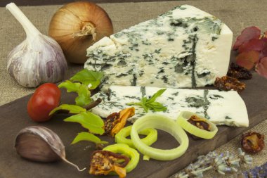 Kalıp ahşap kesme tahtası ile peynir. Aromatik peynir hazırlanması. Stilton peyniri ahşap peynir gemide. Bir tablo üzerinde Danimarka mavi peynir dilimleri.