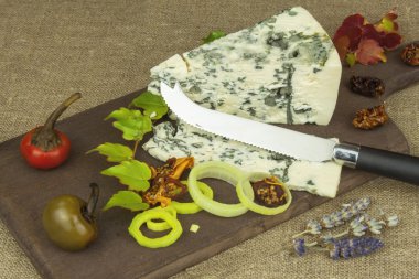 Kalıp ahşap kesme tahtası ile peynir. Aromatik peynir hazırlanması. Stilton peyniri ahşap peynir gemide. Bir tablo üzerinde Danimarka mavi peynir dilimleri.