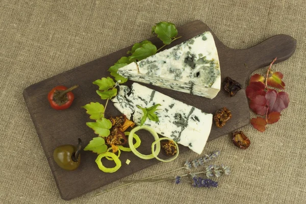 Kalıp ahşap kesme tahtası ile peynir. Aromatik peynir hazırlanması. Stilton peyniri ahşap peynir gemide. Bir tablo üzerinde Danimarka mavi peynir dilimleri.